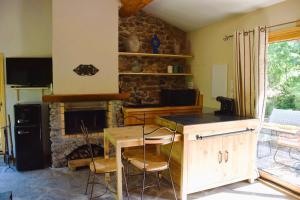 a kitchen with a table and a stone fireplace at Gite de Lise in Blandas