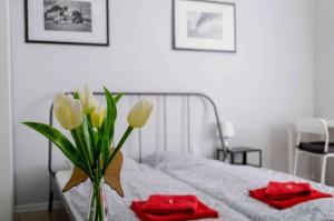 a vase of flowers sitting on a bed with red napkins at Penzion Zacha se sklípkem in Vracov