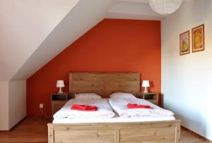 a bedroom with a bed with two red pillows on it at Penzion Zacha se sklípkem in Vracov +15 photos
