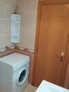 a bathroom with a washing machine and a wooden door at Apartamento Maru's in Oropesa del Mar