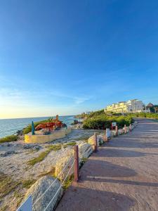 a road next to the ocean with a fence at Casa Roca II in Isla Mujeres