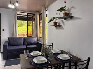 a living room with a table and a couch at Harmony Home La Fortuna in Fortuna