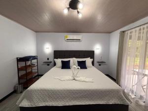 a bedroom with a bed with a towel on it at Harmony Home La Fortuna in Fortuna