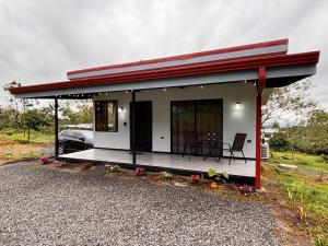 a small house with a deck and a car at Harmony Home La Fortuna in Fortuna