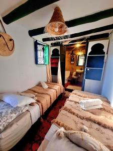 a group of beds in a room with a room with at riad cherif in Marrakesh