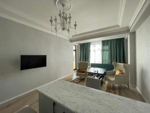 a kitchen and living room with a table and a couch at Caspian Mirvari in Sumqayıt