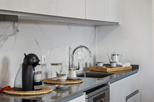 a kitchen with a counter top with tea pots on it at Johns Villa by Homie in Canhas
