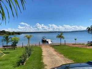 a boat is docked on the shore of a lake at Chalés Brisas do Lago Capitólio in Capitólio +11 photos