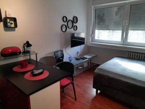 a small room with a bed and a desk and a bed and a table at Koleos in Osijek