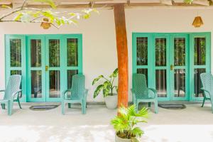 a group of blue chairs on a patio at Lazy Monkey Green Chalets in Hiriketiya +8 photos