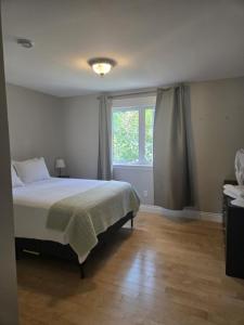 a bedroom with a large bed and a window at Calm on the Crescent in St. John's