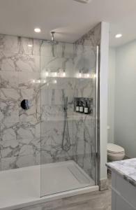 a bathroom with a shower with a glass door at Calm on the Crescent in St. John's +15 photos