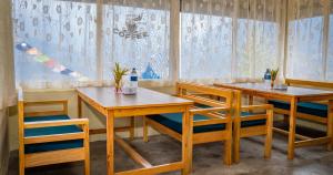 two wooden tables and chairs in a room at Chautari Hotel & Restaurant in Astam
