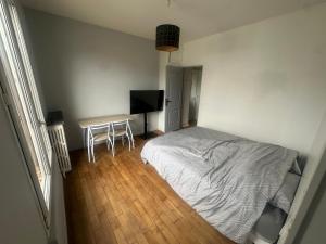 a bedroom with a bed and a desk with a television at Chambre privee dans une maison 2 in Aulnay-sous-Bois