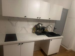 a kitchen with white cabinets and a counter top at Chambre privee dans une maison 2 in Aulnay-sous-Bois