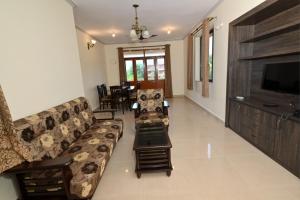 a living room with a couch and a flat screen tv at Scandi-Stay 2BR by Benaulim Beach in Benaulim