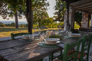 a wooden table with plates and wine glasses on it at Tre Cercole - Eco Resort in San Marco in Lamis