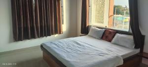 a bed sitting in a room with a window at Shyam Krapa in Rīngas