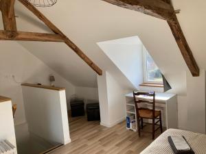 a attic room with a desk and a window at La suite de L'Eau qui dort in Pleslin-Trigavou