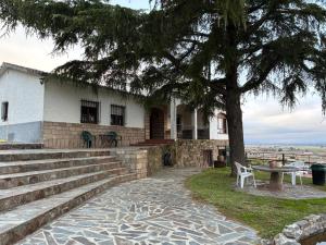 a building with stairs and a tree in front of it at El Cerro del Pinar in Oropesa