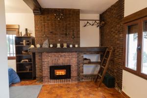 a fireplace in a living room with a brick wall at El Cerro del Pinar in Oropesa