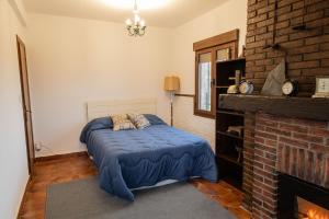 a bedroom with a bed and a brick fireplace at El Cerro del Pinar in Oropesa