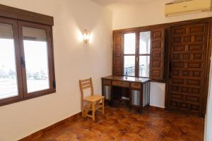 a room with a desk and a chair and windows at El Cerro del Pinar in Oropesa +28 photos