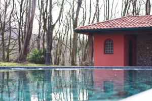 a red house next to a swimming pool at Maison d'Hôtes HAITZ TEYA - La Chênaie in Ascain