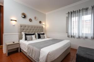 a bedroom with a large bed and a window at Rosa dos Ventos in Zambujeira do Mar +99 photos