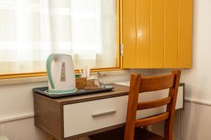 a desk with a mirror and a chair in a room at Rosa dos Ventos in Zambujeira do Mar