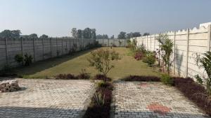 a garden with a wall and a brick pathway at The Green Retreat in Murthal