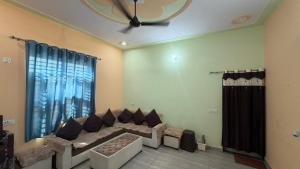 a living room with a couch and a large window at The Green Retreat in Murthal