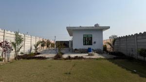 a small house in front of a fence at The Green Retreat in Murthal