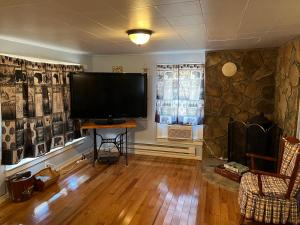 a living room with a large flat screen tv at Cochran Farm House in Bryson City