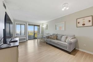 a living room with a couch and a television at Coastal 2BR Condo w Ocean Views & Pool in Hilton Head Island