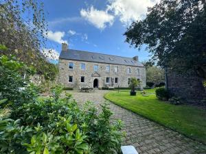 a large stone building with a pathway in front of it at LE DOMAINE DE COAT ROGAN, La chambre du Jaudy in Pommerit-Jaudy