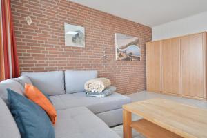 a living room with a couch and a brick wall at FeWo Lange - Whg 48 in Kellenhusen