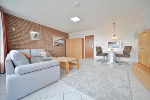 a living room with a couch and a table at FeWo Lange - Whg 48 in Kellenhusen +18 photos