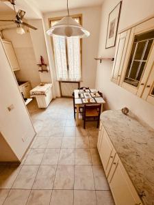 a kitchen with a table in the middle of it at Novecento Apartment in Forlì +35 photos