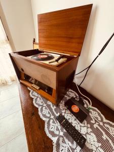 a wooden box with a record player on a floor at Novecento Apartment in Forlì
