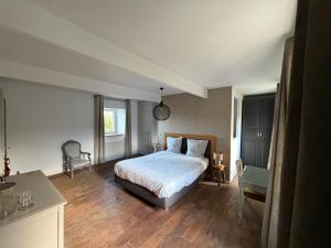 a bedroom with a bed and a table and a chair at LE DOMAINE DE COAT ROGAN, La chambre du Jaudy in Pommerit-Jaudy +3 photos