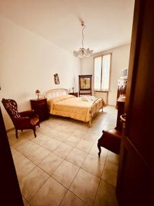 a bedroom with a bed and a chair at Novecento Apartment in Forlì