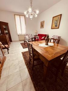 a dining room with a wooden table and chairs at Novecento Apartment in Forlì