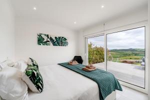 a bedroom with a bed and a large window at Villa Adão Lobo in Cadaval +114 photos