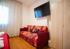 a living room with a red couch and a flat screen tv at La madonnuccia in Deruta