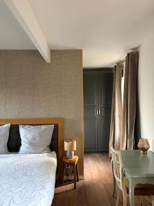 a bedroom with a bed and a table at LE DOMAINE DE COAT ROGAN, La chambre du Jaudy in Pommerit-Jaudy