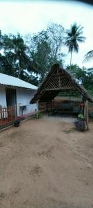 a pavilion with a table and a palm tree at Mango Mango in Tangalle