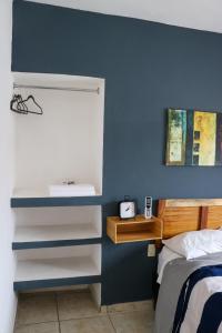 a bedroom with a blue wall with a bed and a desk at Departamentos Perfectamente ubicados con alberca in Ciudad Madero