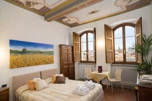 a bedroom with a bed and a painting on the wall at La Corte Del Re Suite & Rooms Arezzo in Arezzo