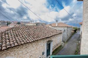an old building with a tile roof on a street at Elitee Superior Mountain Residence in Vitina